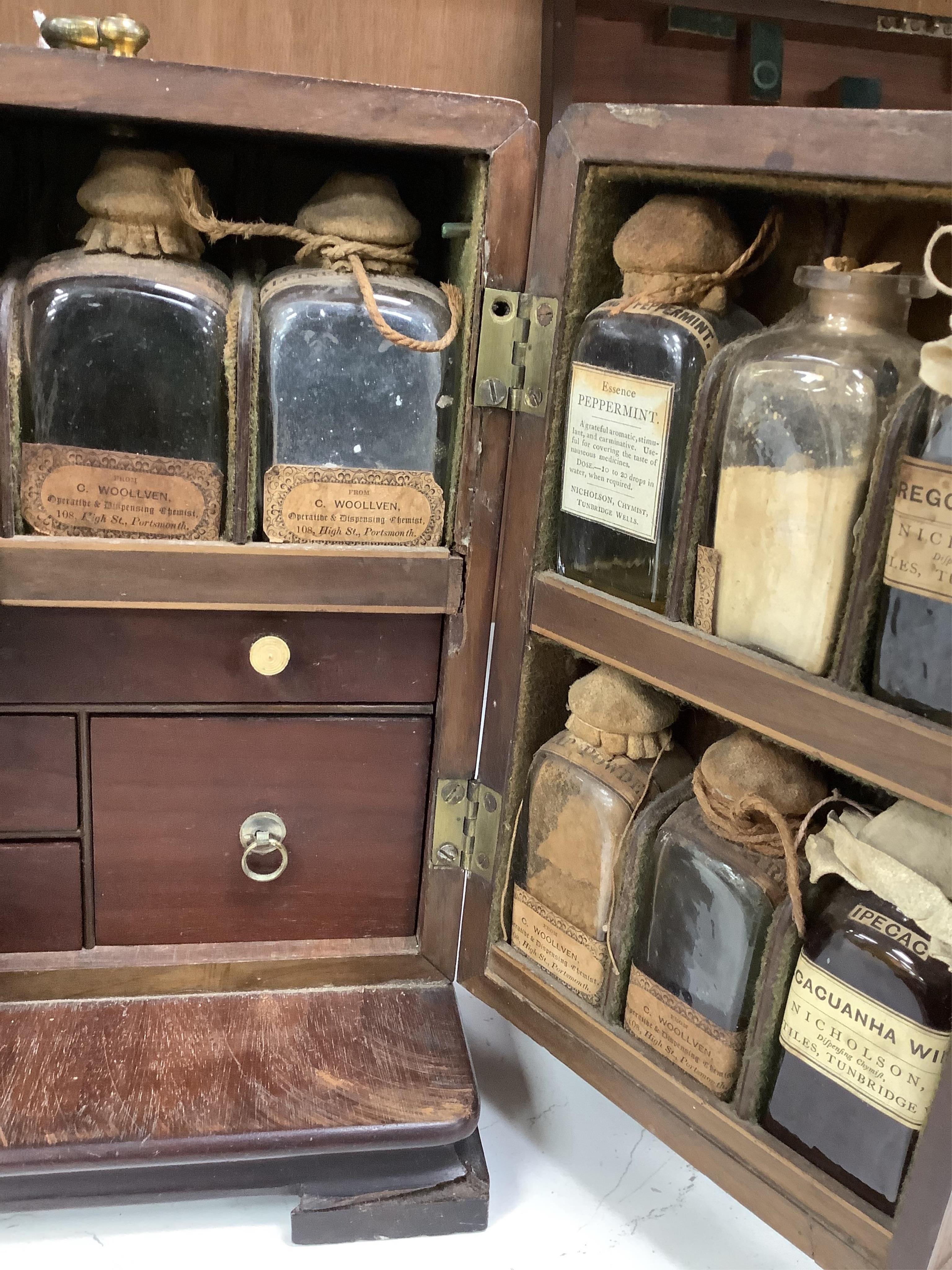 A 19th century mahogany apothecary cabinet, containing 20 bottles of various medicinal compounds and poisons, some sealed, all with paper labels, mainly for ‘C. Woollven, Operative & Dispensing Chemist, 108, High Street,